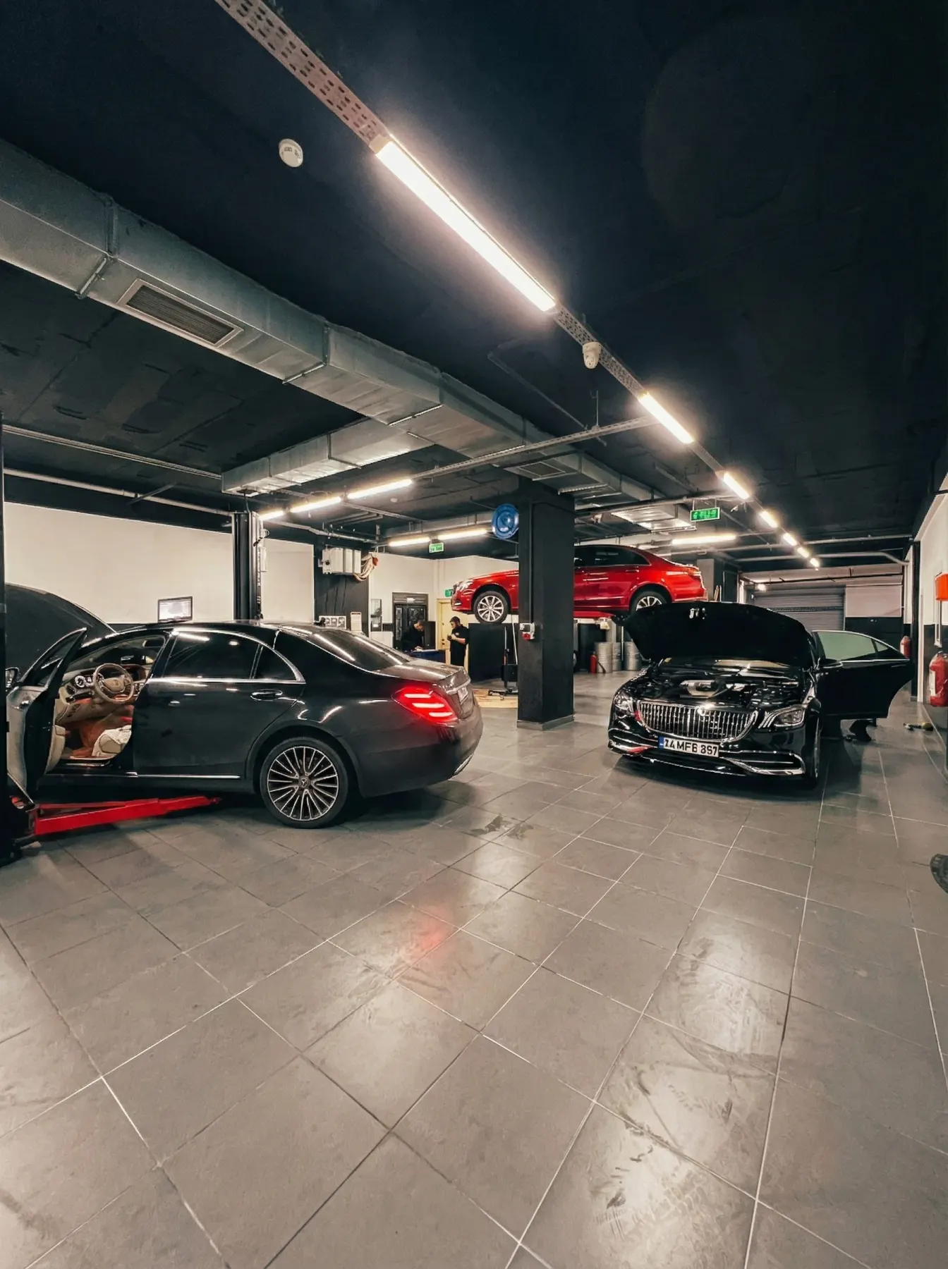 Alt kat atölyede motor revizyonu için lifte alınmış Mercedes-AMG GLE
